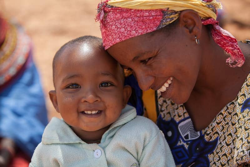 Smiling mother and child enjoying a happy moment together outdoors, reflecting joy and love.