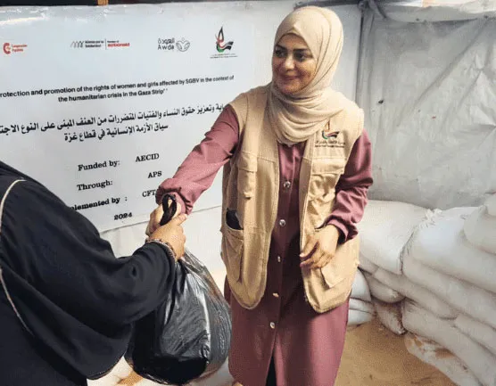 Humanitarian aid worker distributing supplies to a woman in a relief center, emphasizing support and assistance.