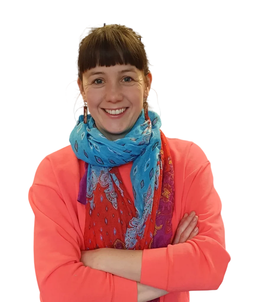 Woman smiling, arms crossed, wearing a colorful scarf and orange sweater, isolated on white background.